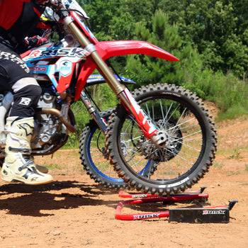 Outdoor picture of two MX riders practicing their starts using Holeshot Pro Gates from a side view